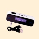 FM transmitter. Audio jack connection, an on off slide switch and frequency adjustment buttons are visible. as is an lcd screen displaying the current frequency range in MHz and the battery level. Also pictured is the charging cable